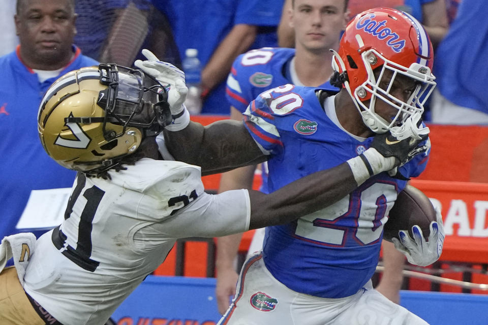 Florida running back Treyaun Webb (20) stiff arms Vanderbilt safety Savion Riley as he tires to get extra yardage during the second half of an NCAA college football game, Saturday, Oct. 7, 2023, in Gainesville, Fla. (AP Photo/John Raoux)