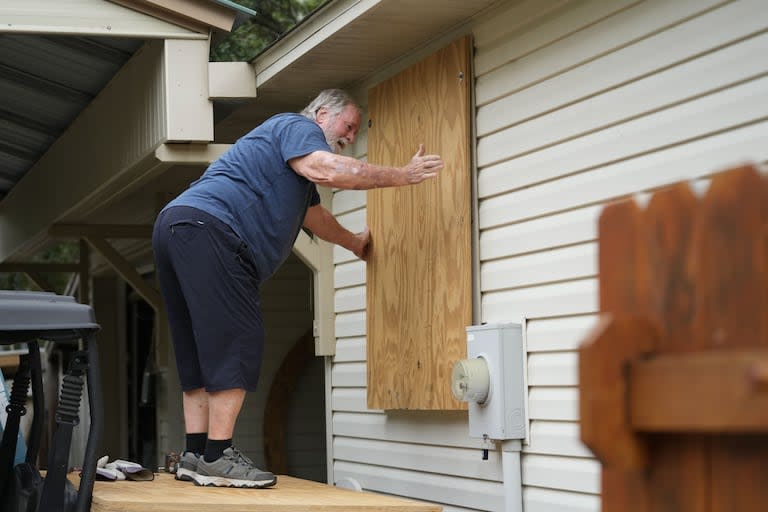 Dave McCurley tapia las ventanas de su casa antes de que llegue la tormenta tropical Helene, que se espera que toque tierra como huracán, en Ochlockonee Bay, Florida