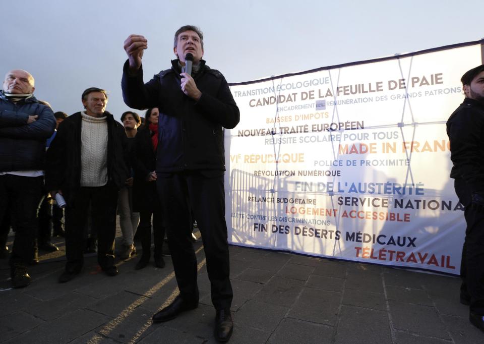 Former Economy minister and now candidate in the French left's presidential primaries Arnaud Montebourg, center, talks during a meeting in the Old-Port of Marseille, southern France, Friday, Jan. 20, 2017. Seven competitors are bidding to be the Socialist Party's candidate in next spring's French presidential election. Banner reads "Candidate of the pay slip-New European treaty-6th republic". (AP Photo/Claude Paris)