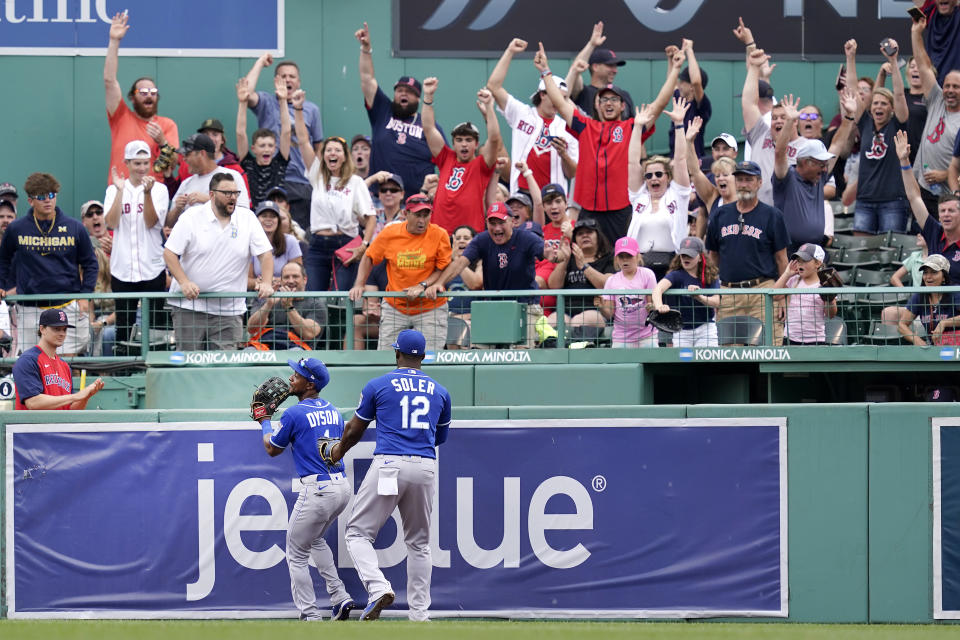 Fans cheer after Kansas City Royals center fielder Jarrod Dyson jumped against the bullpen wall in an effort to catch Boston Red Sox's Danny Santana's three-run homer in the fourth inning of a baseball game at Fenway Park, Thursday, July 1, 2021, in Boston. Royals right fielder Jorge Soler (12) helps Dyson get his balance. (AP Photo/Elise Amendola)