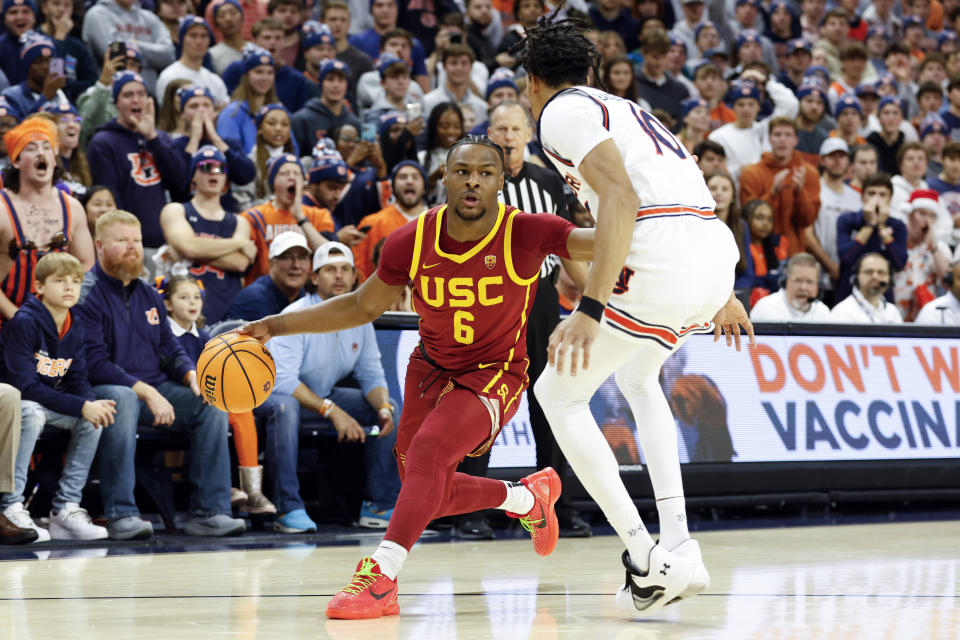 USC guard Bronny James (6) dribbles around Auburn guard Chad Baker-Mazara (10) during the first half of an NCAA basketball game, Sunday, Dec. 17, 2023, in Auburn, Ala. (AP Photo/Butch Dill)