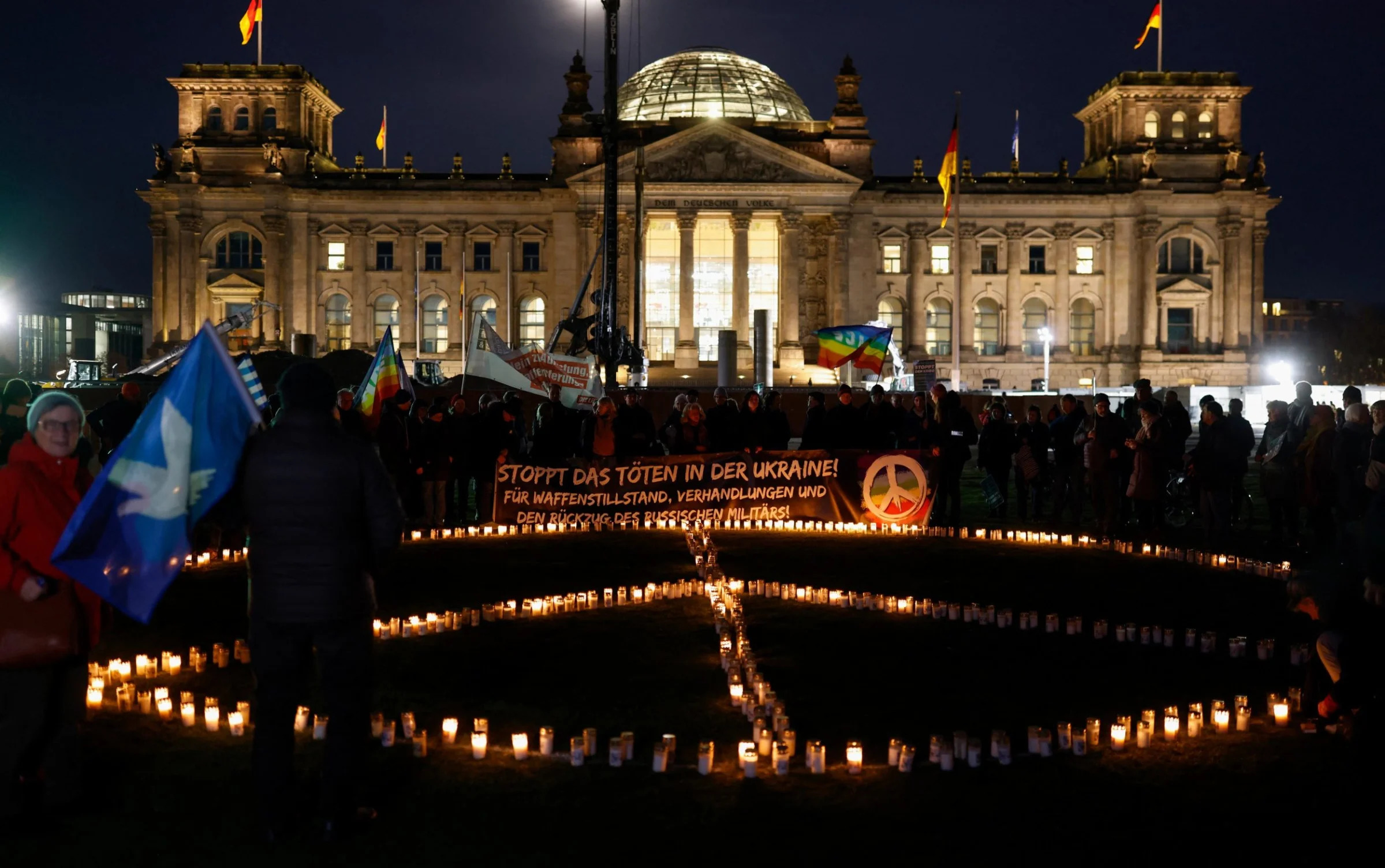 A peace sign made with candles by protestors during a rally marking the eve of the second anniversary of Russia's invasion of Ukraine