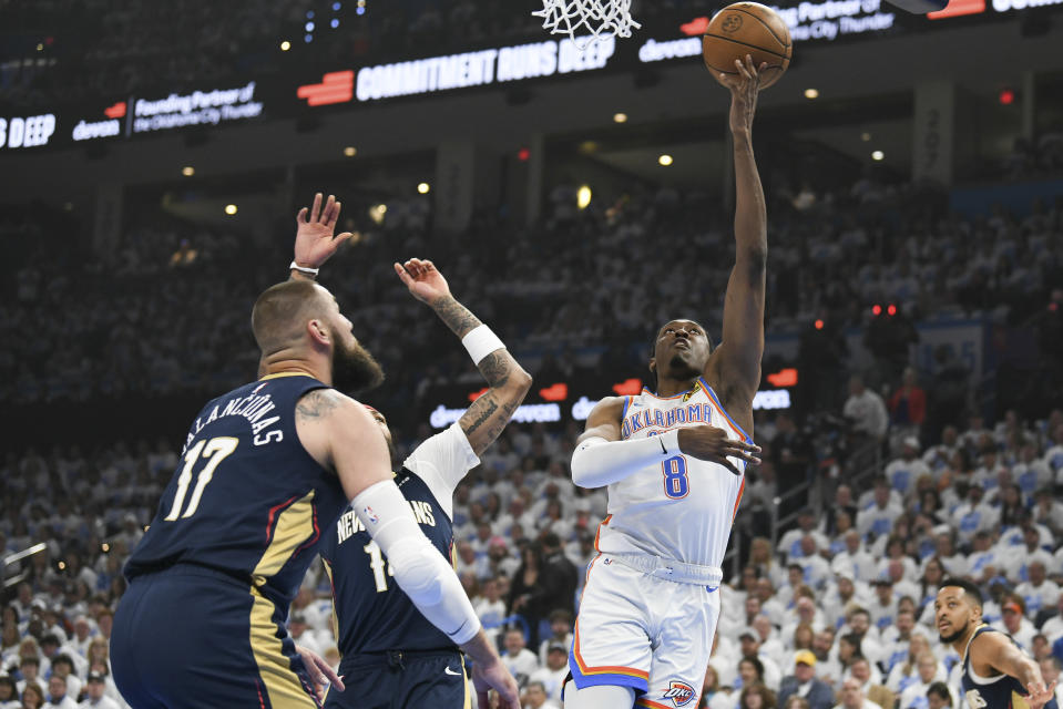Oklahoma City Thunder forward Jalen Williams (8) shoots around New Orleans Pelicans center Jonas Valanciunas (17) and forward Brandon Ingram, middle, in the first half of Game 1 of an NBA basketball first-round playoff series, Sunday, April 21, 2024, in Oklahoma City. (AP Photo/Kyle Phillips)