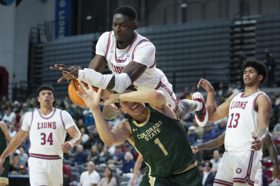 Loyola Marymount center Rick Issanza, top, collides with Colorado State forward Joel Scott during the first half of an NCAA college basketball game Friday, Dec. 22, 2023, in Los Angeles. (AP Photo/Ryan Sun)
