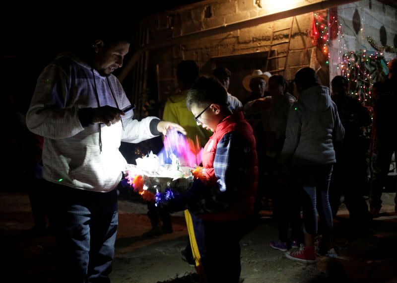 Jesus Mendoza and his son Isaiah Mendoza 9, look at the candies collected from a pinata during a posada in Jalpan de Serra