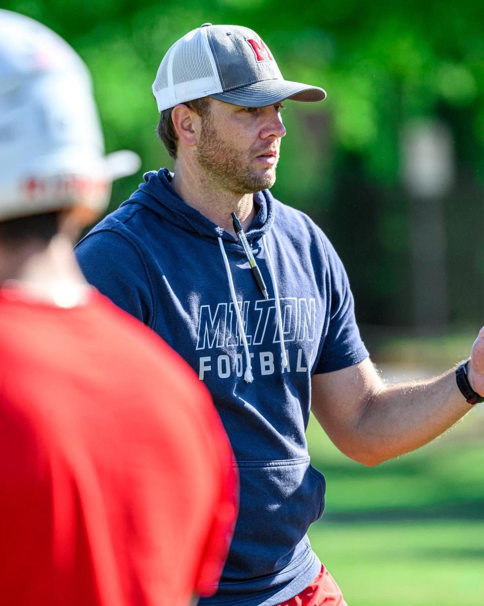 Milton High School head football coach Ben Reaves coaches during a practice.