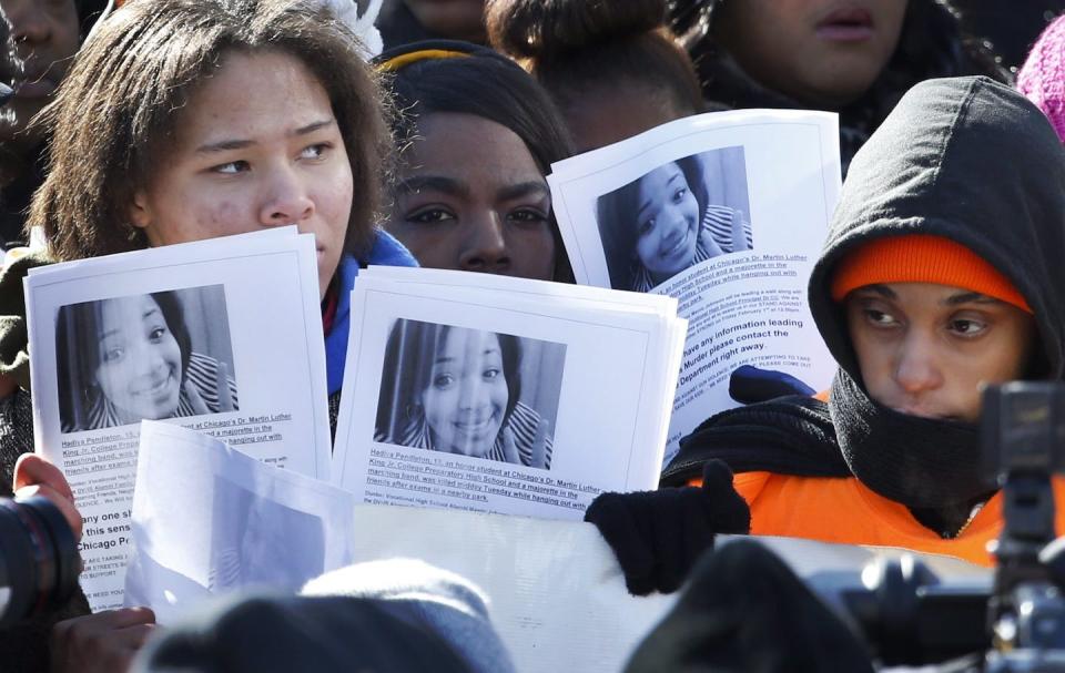 Protesters hold up copied photos of Hadiya Pendleton at the scene where she was killed during an anti-gun violence march and rally Friday, Feb. 1, 2013, in Chicago. (AP Photo/Charles Rex Arbogast)