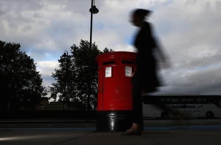 A woman walks past a Royal Mail post box in central London, October 8, 2013. REUTERS/Andrew Winning