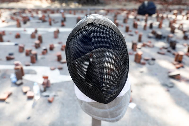 A fencing mask that belongs to an anti-government protester is seen on a road scattered with bricks outside the Polytechnic University in Hong Kong