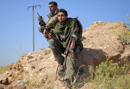 Fighters from the Syrian Democratic Forces (SDF) hold walkie-talkies in the village of Baghouz, Deir Al Zor province, Syria March 20, 2019. Picture taken March 20, 2019. REUTERS/Rodi Said