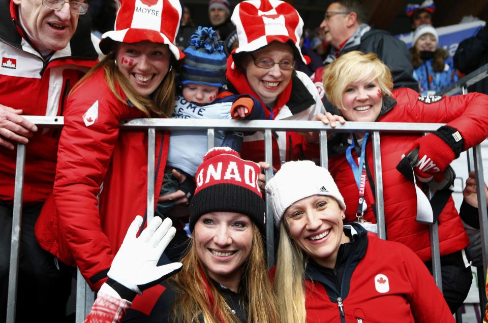 Canada's pilot Kaillie Humphries (R) and Heather Moyse (L) celebrate with family members after winning the women's bobsleigh event at the Sochi 2014 Winter Olympics February 19, 2014. REUTERS/Arnd Wiegmann (RUSSIA - Tags: OLYMPICS SPORT BOBSLEIGH)