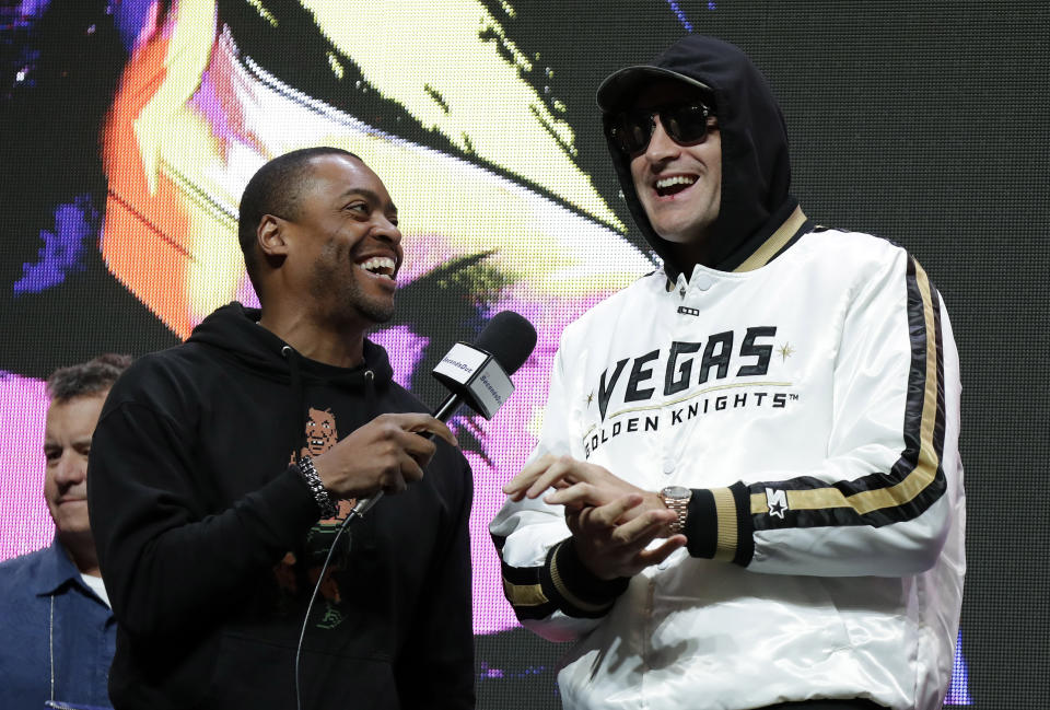 El británico Tyson Fury, a la derecha, hace declaraciones a la prensa sobre su próxima pelea por el campeonato de peso completo de la OMB contra Deontay Wilder, el miércoles 19 de febrero de 2020, en Las Vegas. (AP Foto/Isaac Brekken)