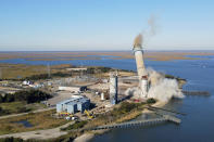 The smokestack at the former B.L. England coal and oil burning power plant in Upper Township, N.J., is toppled during a control demolition on Thursday, October 26, 2023. The site will be redeveloped as a mixed-use residential and commercial project, and a nearby electrical substation will be used to connect New Jersey's soon-to-come offshore wind farms with the electrical grid. (AP Photo/Ted Shaffrey)