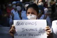 A Respiratory Hospital INERAM nurse holds the Spanish message "We want supplies! Be strong INERAM!," during a protest demanding more materials for the ICU in Asuncion, Paraguay, Wednesday, March 3, 2021, the day after INERAM Director Felipe Gonzalez resigned. Without vaccines or basic drugs to combat COVID-19, Paraguay's main public hospitals became unable to receive patients in intensive care units on Wednesday. (AP Photo/Jorge Saenz)