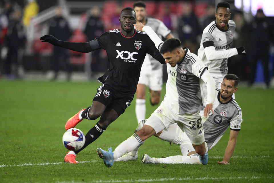 D.C. United forward Christian Benteke, left, and Toronto FC defender Raoul Petretta (28) battle for the ball during the second half of an MLS soccer match, Saturday, Feb. 25, 2023, in Washington. (AP Photo/Nick Wass)