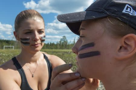 Players of SuoSiat get a war paint on their faces before the game at the Swamp Soccer World Championships tournament in Hyrynsalmi, Finland July 13, 2018. Picture taken July 13, 2018. Lehtikuva/Kimmo Rauatmaa/via REUTERS