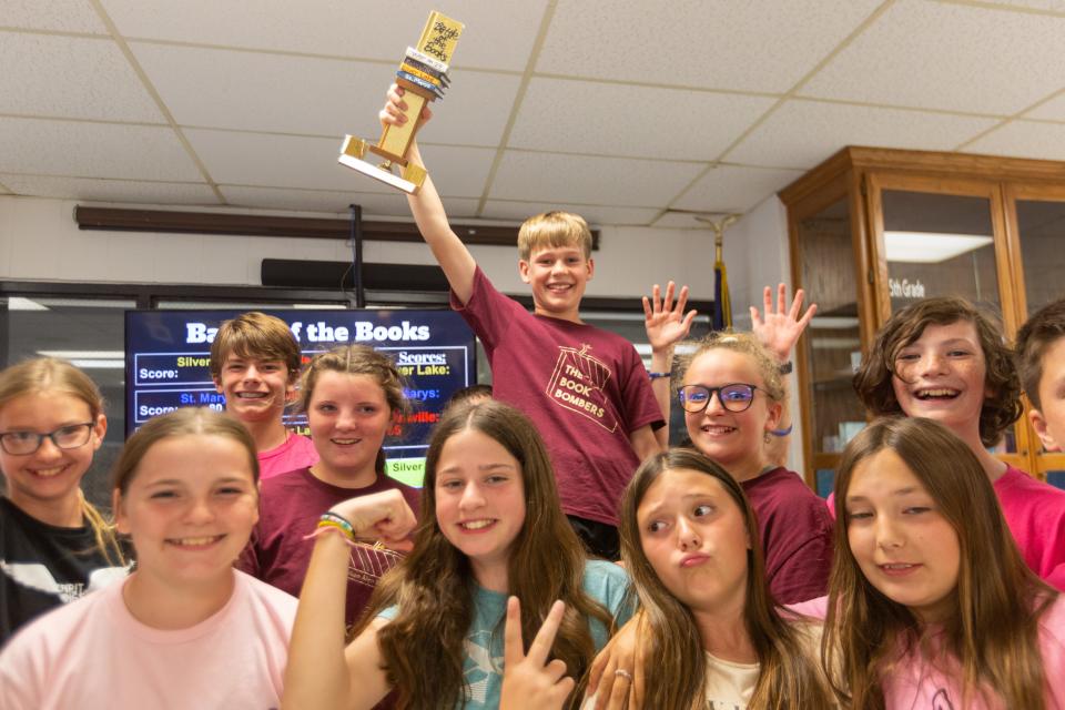 Silver Lake sixth-grader Caleb Heier holds up the Battle of the Books trophy his team earned Wednesday afternoon after facing St. Marys and Rossville in an elementary school version of the War on 24.