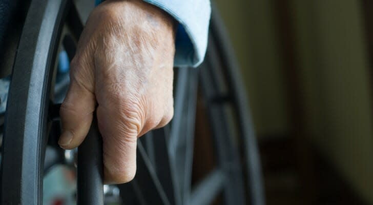 Senior's hand on a wheelchair wheel