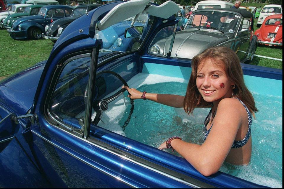 <i>Thirteen-year-old Stephanie takes a bath in a converted Volkswagen Beetle at the 6th Beetle meeting in Chateau-d'Oex, Switzerland, on Aug. 31, 1996.</i>