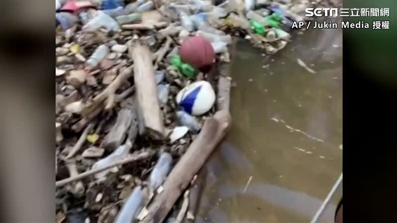 河中甚至還能看見好幾顆籃球及安全帽這類的大型垃圾（圖／AP/Jukin Media 授權）