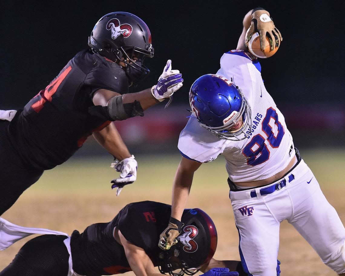 Rolesville’s Isaiah Kozar (2) and Jalen Butts (54) leap to tackle Wake Forest’s David Sanchez (80). The Wake Forest Cougars and the Rolesville Rams met in a NCHSAA 4AA Regional Round football game in Rolesville, N.C. on April 20, 2021.