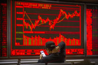 A Chinese investor uses his smartphone as he monitors stock prices at a brokerage house in Beijing, Tuesday, Nov. 19, 2019. Asian shares were mixed Tuesday as investor sentiment remained cautious amid worries about the next development in trade talks between the United States and China. (AP Photo/Mark Schiefelbein)