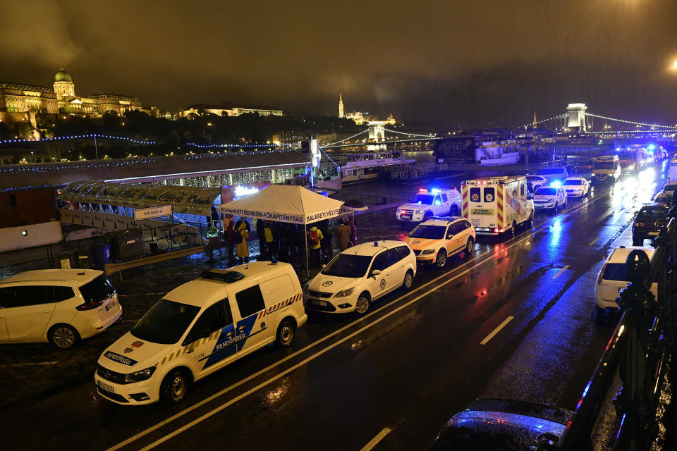FILE - In this Thursday, May 30, 2019 file photo, police and ambulances are parked on the river bank after a tourist boat crashed with a river cruise boat in River Danube in Budapest, Hungary. Hungarian prosecutors say they have charged the captain of a cruise ship involved in the May 2019 collision on the Danube River in which 28 people were killed..(Zsolt Szigetvary/MTI via AP, file)