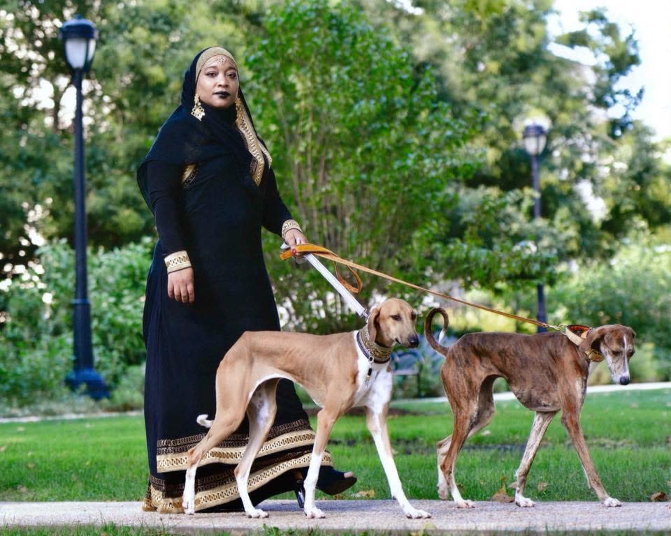 Aliya Taylor walks with two Azawakh, a rare breed of sighthound from Africa, while wearing a black abaya. (Photo: Terri Hirsch)