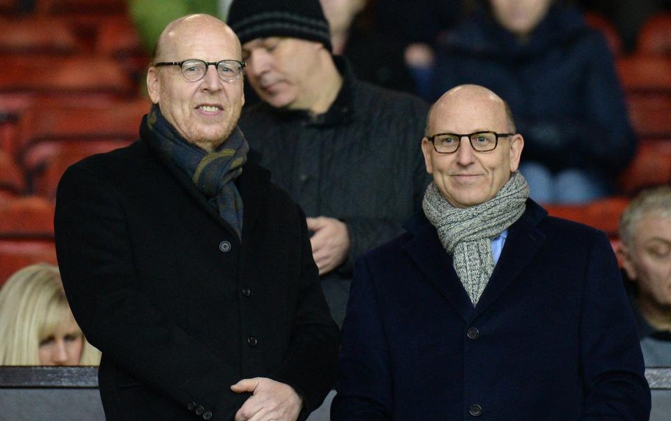 Manchester United's co-chairpeople Joel Glazer and Avram Glazer (L) prepare to watch the English Premier League football match between Manchester United and Burnle