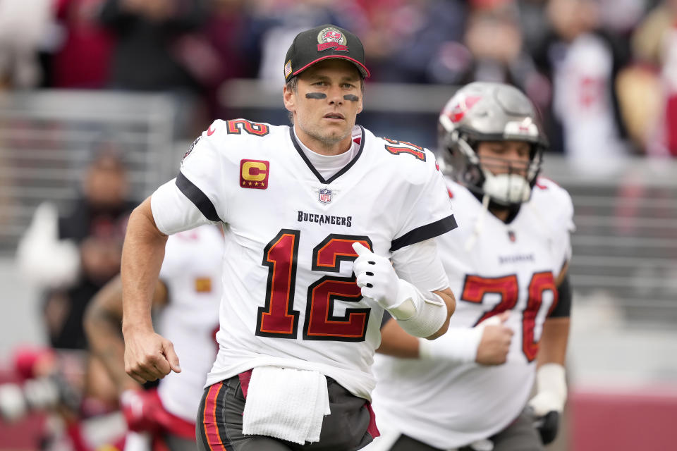 FILE - Tampa Bay Buccaneers quarterback Tom Brady (12) runs on the field before an NFL football game against the San Francisco 49ers in Santa Clara, Calif., Sunday, Dec. 11, 2022. The bankruptcy of FTX and the arrest of its founder and former CEO are raising new questions about the role celebrity athletes such as Brady, Steph Curry, Naomi Osaka and others played in lending legitimacy to the largely unregulated landscape of crypto, while also reframing the conversation about just how costly blind loyalty to favorite players or teams can be for the average fan. (AP Photo/Tony Avelar, File)