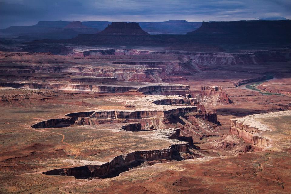 Canyonlands National Park is vast. A view from Green River Overlook, high above a 1,500-foot mesa in the Island of the Sky, highlights the light-colored, aeolian (dune deposits) flat sedimentary rocks of the White Rim Sandstone.