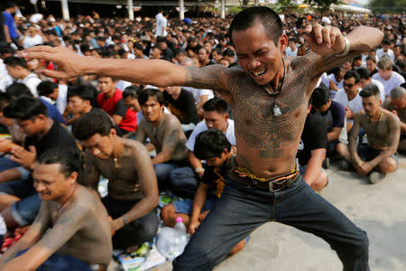 A devotee in trance mimics a beast during a religious tattoo festival at Wat Bang Phra, where devotees come to recharge the power of their sacred tattoos, in Nakhon Pathom province, Thailand, March 11, 2017. REUTERS/Jorge Silva