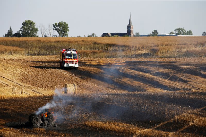 French firefighters extinguish a burning wheat field in Beauvois-en-Cambresis