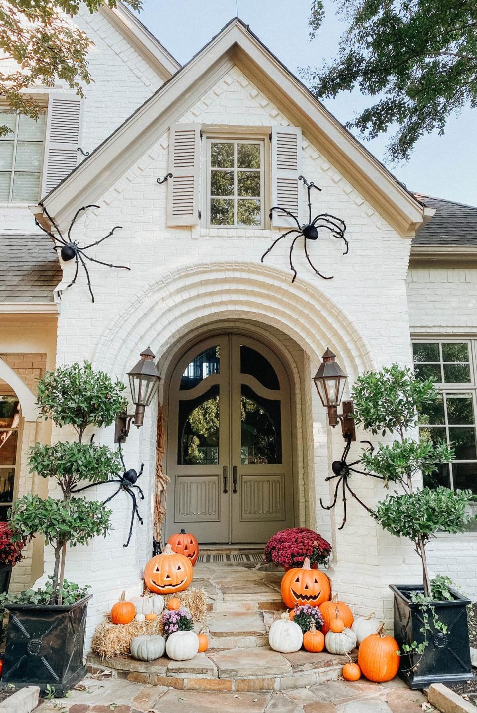 fall porch with large spiders hay and pumpkins