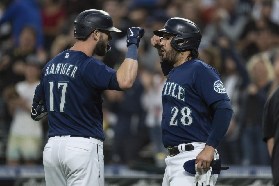 Seattle Mariners' Mitch Haniger, left, is congratulated by Eugenio Suarez after hitting a two-run home run off Texas Rangers starting pitcher Jon Gray during the first inning of a baseball game Thursday, Sept. 29, 2022, in Seattle. (AP Photo/Stephen Brashear)