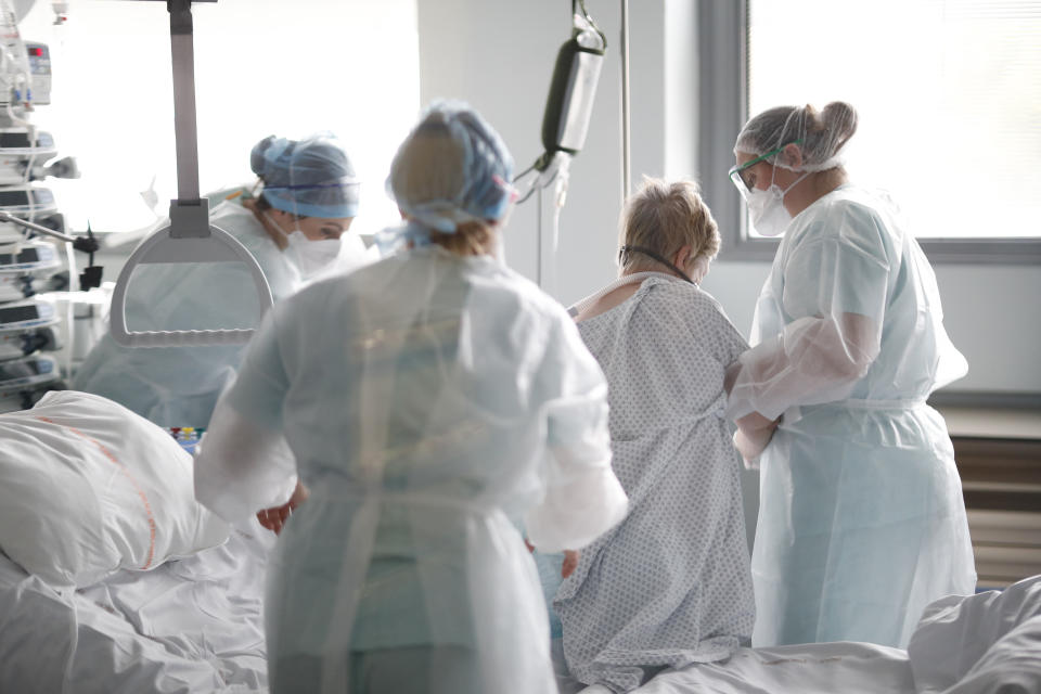 Medical workers help a patient suffering of COVID-19 in the Nouvel Hopital Civil of Strasbourg, eastern France, Thursday, Oct.22, 2020. France has seen over 34,000 confirmed deaths in the pandemic. (AP Photo/Jean-Francois Badias)