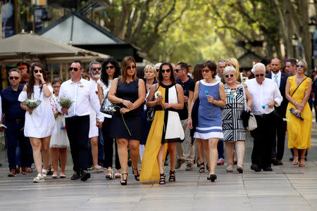 Relatives react as they arrive to place flowers in memory of victims of the twin Islamist attacks on the Catalan capital and the coastal town of Cambrils that killed 16 people, during a ceremony to mark the first anniversary of the attacks at Las Ramblas, central Barcelona, Spain, August 17, 2018. REUTERS/Albert Salame