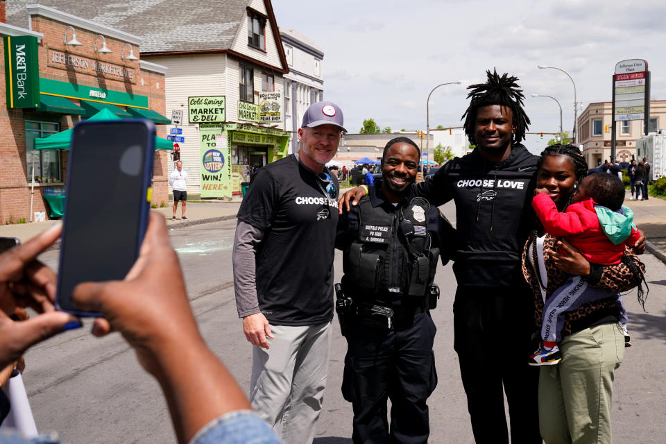 Buffalo Bills' Josh Thomas, second right, and coach Sean McDermott, center left, poses for a photograph near the scene of Saturday's shooting at a supermarket, in Buffalo, N.Y., Wednesday, May 18, 2022. (AP Photo/Matt Rourke)