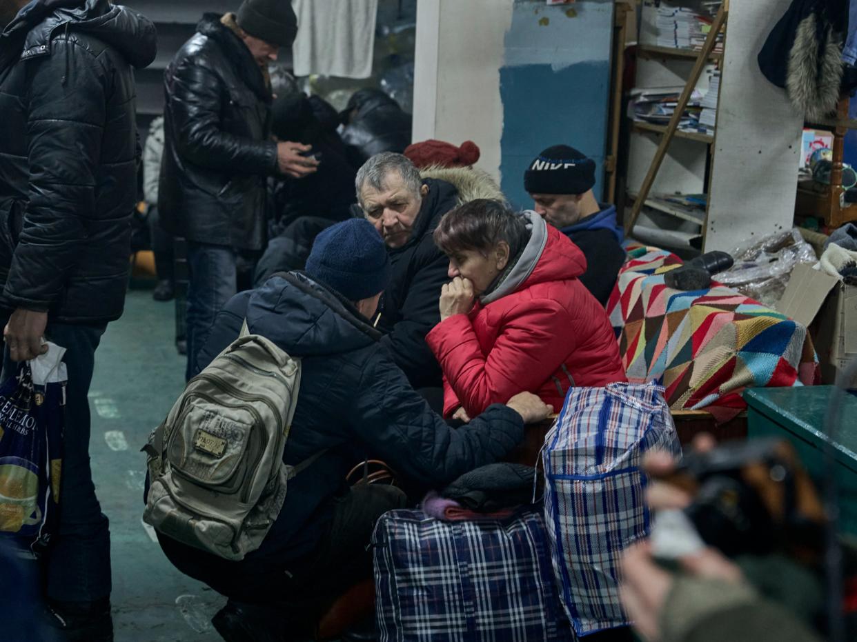 Local residents warm up in a shelter (AP)