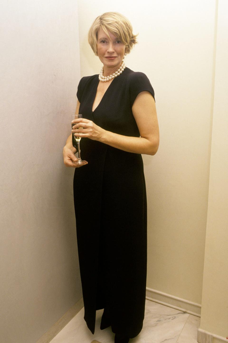 Looking ever-so-chic in a floor-length black gown and pearls, topped off with a bit of champagne! 