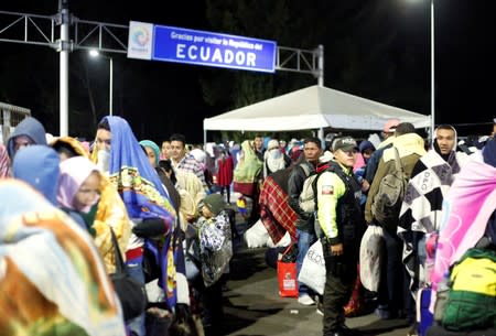 Venezuelans gather to cross into Ecuador from Colombia, as new visa restrictions from the Ecuadorian government took effect, at Rumichaca border bridge in Tulcan