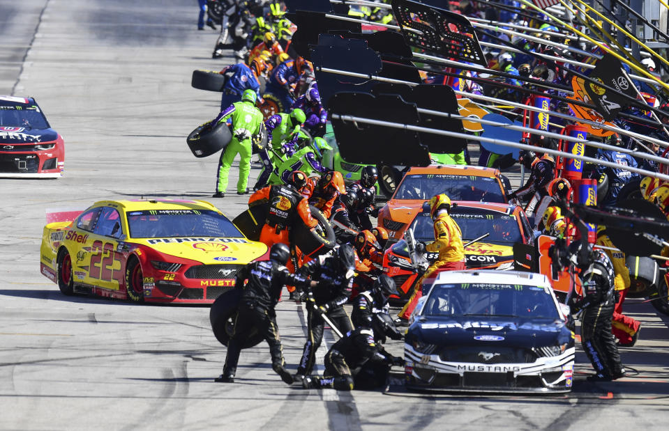 Joey Logano (22) pulls in to make a pit stop behind Aric Almirola during a NASCAR Monster Energy NASCAR Cup Series auto race at Atlanta Motor Speedway, Sunday, Feb. 24, 2019, in Hampton, Ga. (AP Photo/Scott Cunningham)