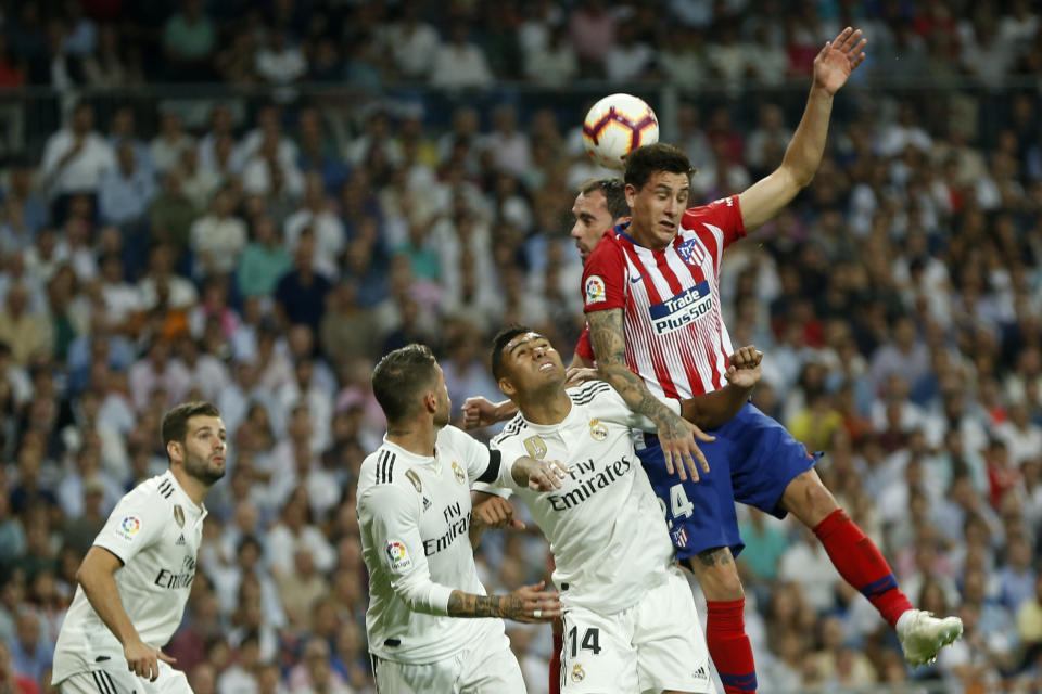 Atletico Madrid's Jose Maria Gimenez, top right, out jumps Real Madrid players during a Spanish La Liga soccer match between Real Madrid and Atletico Madrid at the Santiago Bernabeu stadium in Madrid, Spain, Saturday, Sept. 29, 2018. (AP Photo/Paul White)