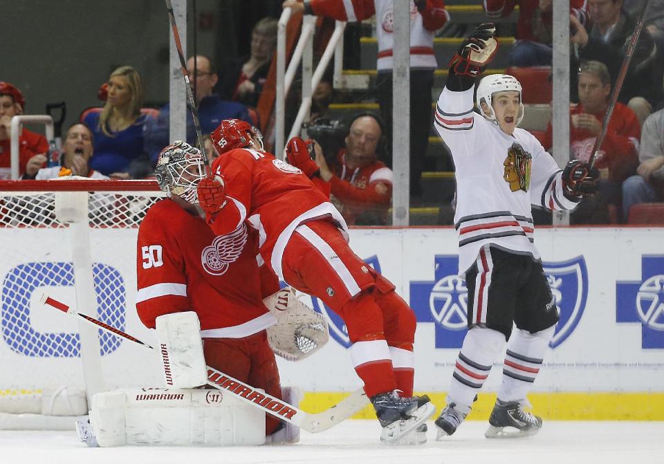 Chicago Blackhawks center Andrew Shaw, right, celebrates Patrick Sharp's goal against Detroit Red Wings goalie Jonas Gustavsson (50), of Sweden, in the second period of an NHL hockey game Wednesday, Jan. 22, 2014, in Detroit. (AP Photo/Paul Sancya)