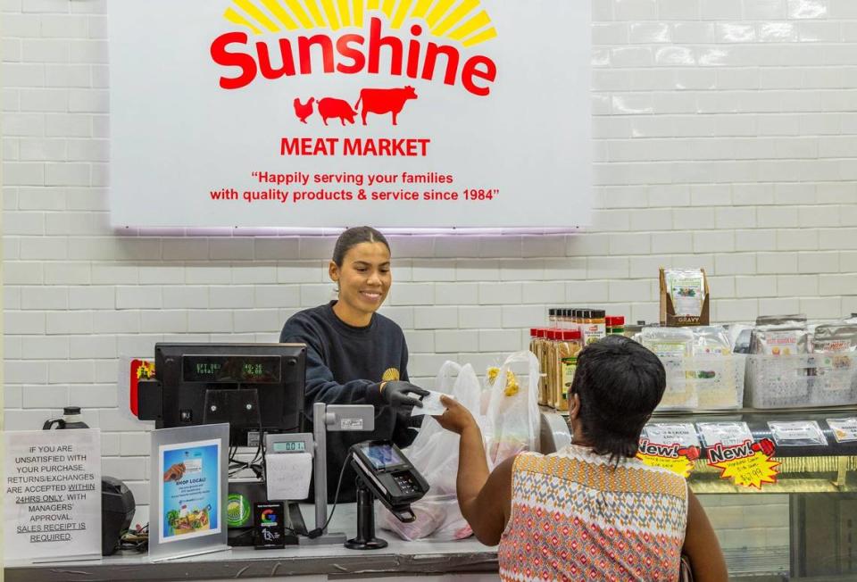 Karissa Disla atendiendo a un cliente en Sunshine Meat Market de su familia en Miami Gardens el miércoles 5 de junio de 2024.