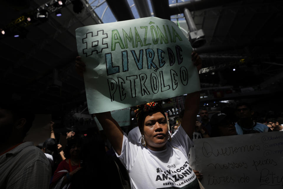 ADDS FRENCH GUIANA - An activist shows a sign that reads in Portuguese "Amazonia free of oil", during a protest by social movements against oil exploration at the mouth of the Amazon River, during the Amazon Dialogue meetings at the Hangar convention center in Belem, Brazil, Sunday, Aug. 6, 2023. The Amazon Dialogues precede the Amazon Summit - IV Meeting of the Presidents of the States party to the Amazon Cooperation Treaty, with the participation of Brazil, Bolivia, Colombia, Guyana, French Guiana, Ecuador, Peru, Suriname and Venezuela. (AP Photo/Eraldo Peres)