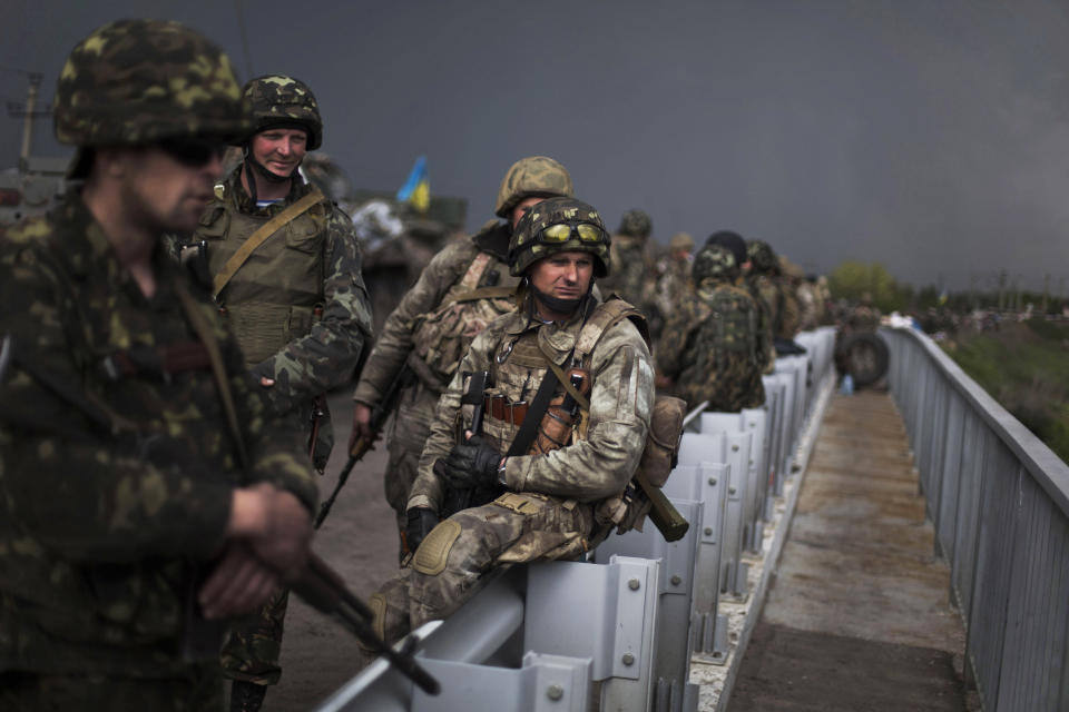 Ukrainian Army soldiers are seen atop of a bridge while Pro Russia civilians block the road in the village of Andreevka, 10 km south of Slavyansk ,Ukraine, Friday, May 2, 2014. Russia has massed tens of thousands of troops in areas near Ukraine’s border. Kiev officials claim Russia is preparing to invade and that it is fomenting the unrest in the east, where insurgents have seized government buildings in about a dozen cities in towns. Moscow denies the allegations, but Foreign Minister Sergey Lavrov has warned Russia would respond to attacks on Russian citizens or interests in the east. (AP Photo / Manu Brabo)