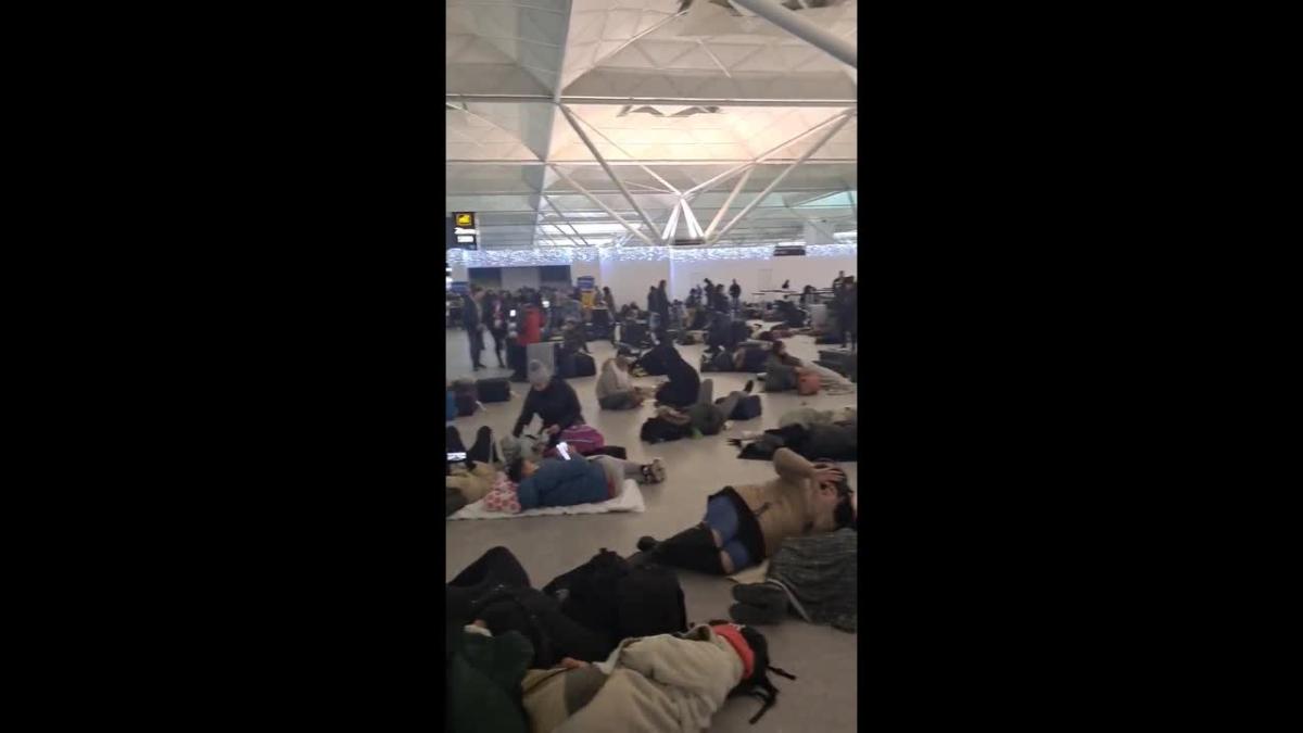 Les gens campent à l’aéroport de Stansted, à Londres, au milieu du chaos de la neige