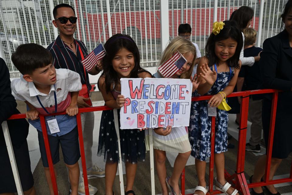 Children of US embassy staff greet US President Joe Biden upon his arrival in Cambodia's Phnom Penh International Airport on November 12, 2022, as he travels to attend the 2022 Association of Southeast Asian Nations (ASEAN) Summit.