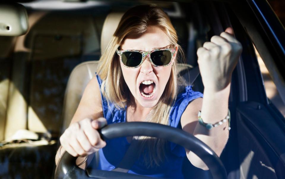 young blonde woman with an attack of road rage and shakes her fist - Don Bayley/Getty Images